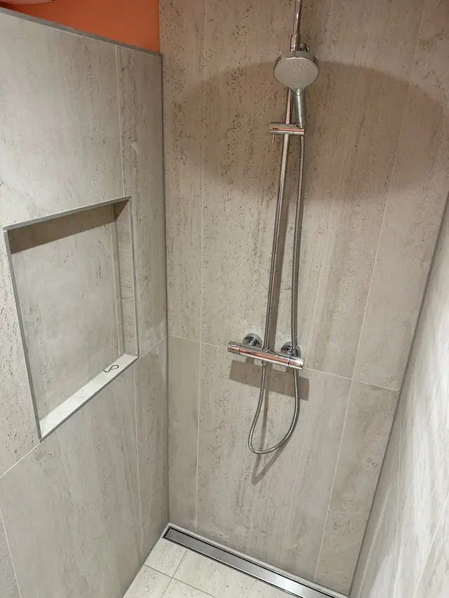 Compacte badkamer met warme accentwand, foto 6 van 7
