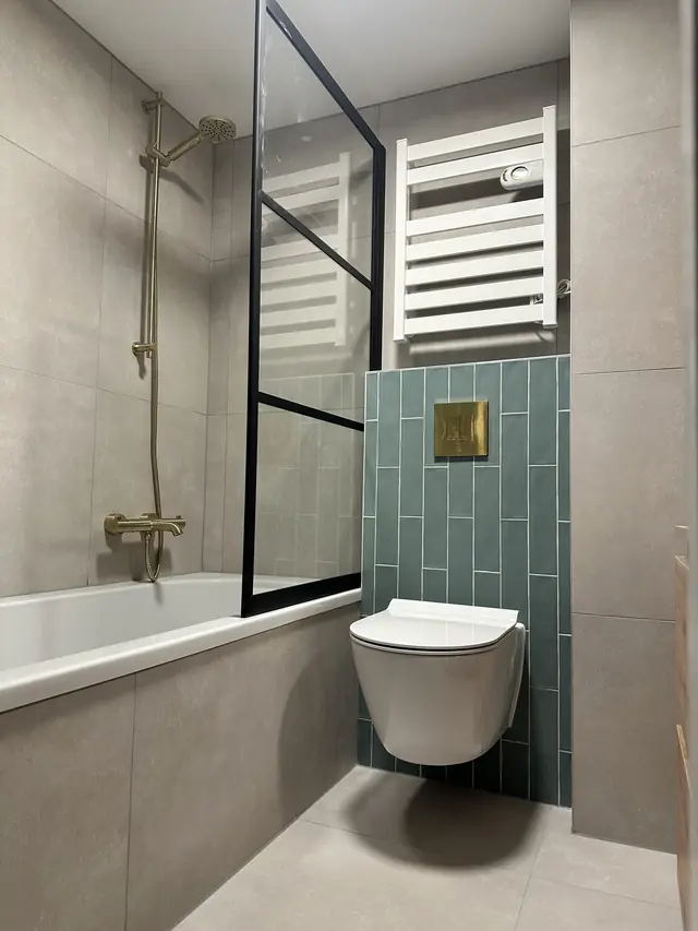 Badkamer met ligbad en groene tegelwand, foto 4 van 7