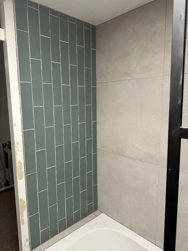 Badkamer met ligbad en groene tegelwand, foto 5 van 7