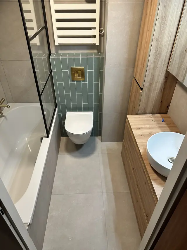 Badkamer met ligbad en groene tegelwand, foto 7 van 7