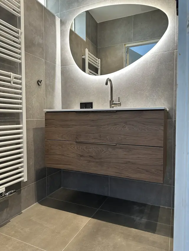 Badkamer in betonlook met verlichte spiegel, foto 2 van 10