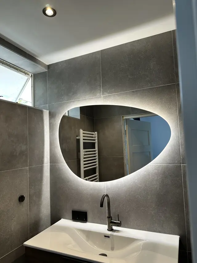 Badkamer in betonlook met verlichte spiegel, foto 3 van 10