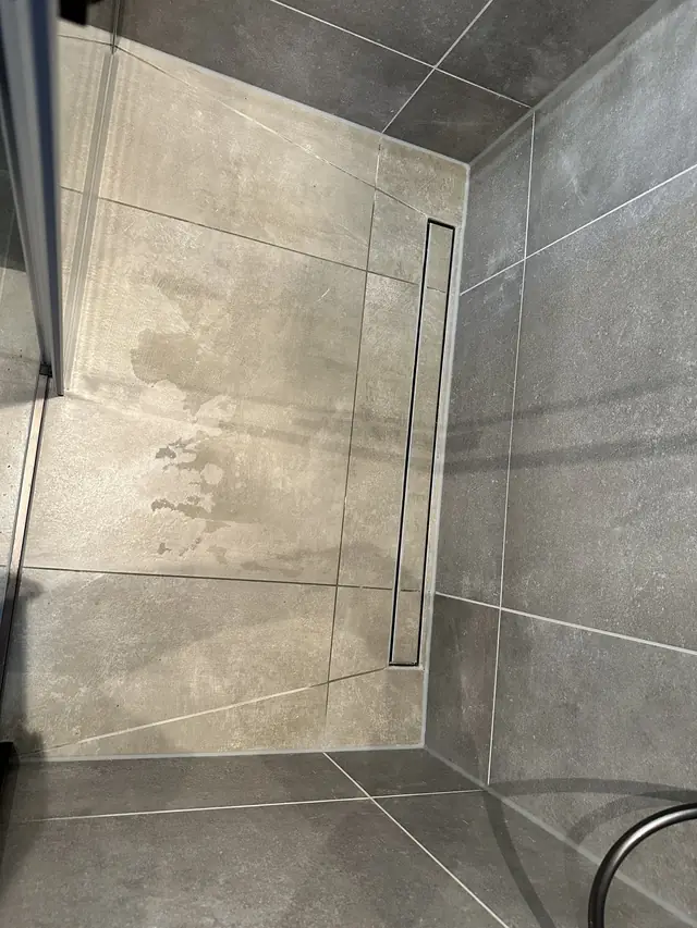 Badkamer in betonlook met verlichte spiegel, foto 6 van 10