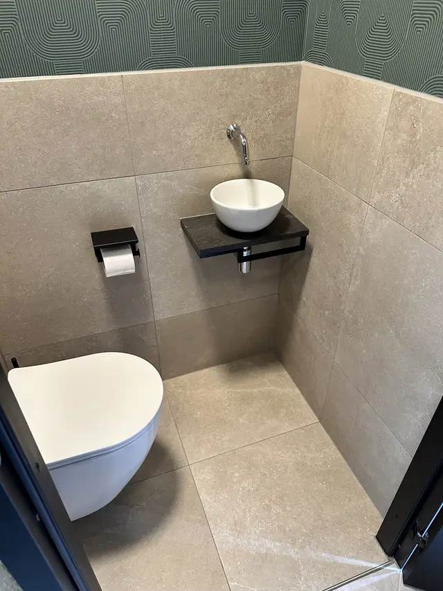 Toilet met groen behang en natuursteentegels, foto 3 van 7