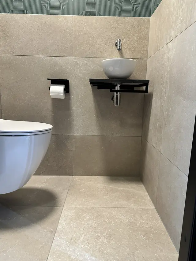 Toilet met groen behang en natuursteentegels, foto 5 van 7