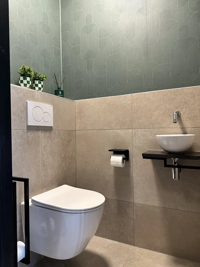 Toilet met groen behang en natuursteentegels, foto 6 van 7